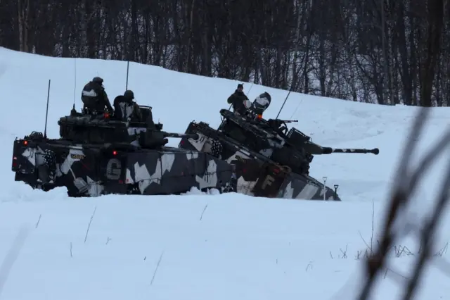 Swedish army members drive infantry fighting vehicles as part of military exercise called "Cold Response 2022", gathering around 30,000 troops from Nato member countries plus Finland and Sweden, in Setermoen in the Artic Circle, Norway, on 25 March 2022