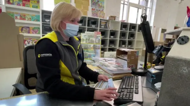 A Ukraine postal worker selling stamps