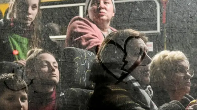 People who flee Mariupol and Melitopol wait inside an evacuee bus at a collecting point in Zaporizhzhia