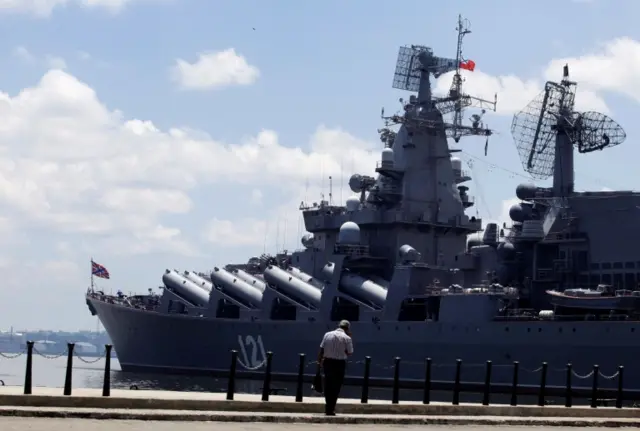 A man walks beside the Russian Moskva Guided Missile Cruiser docked at Havana port, Cuba August 3, 2013