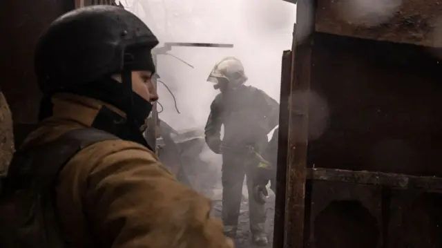 Ukraine forces work to extinguish a warehouse fire in Kharkiv after Russian shelling