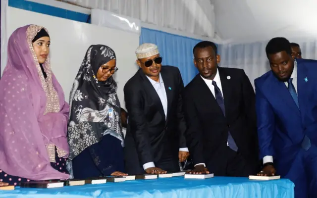 Somalia's newly elected lawmakers place their hands on copies of the Koran as they are sworn in to office at the Afisyoni election hall in Mogadishu, Somalia, April 14, 2022