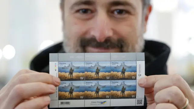 Ihor Smilianskyi, CEO of the Ukrainian post service, holding the stamps