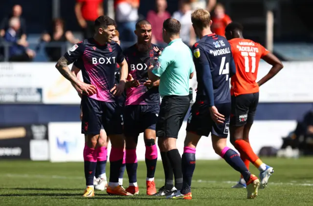 Lewis Grabban of Nottingham Forest argues with referee James Linington after he awards Luton a penalty