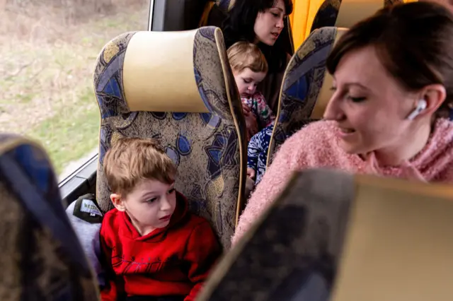 Ukrainian refugees sit in an Abdar Polish travel agency coach on their way from Lviv heading for Poland on 12 April