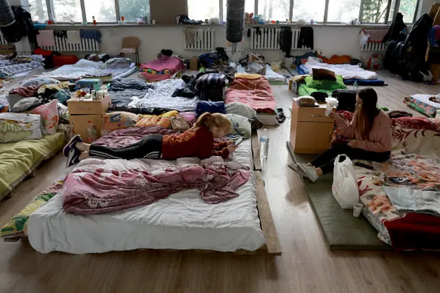 Two teen Ukrainian srelax at a center for displaced people set up in a gymnasium in Lviv