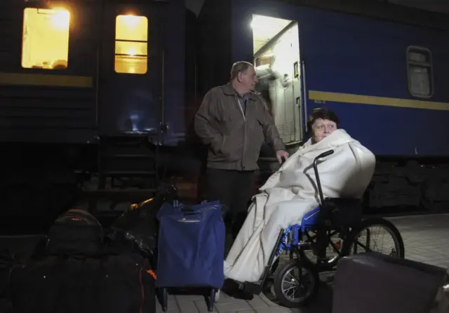 Volunteers assist disabled and old refugees from the Luhansk region at the main railway station of the western city of Lviv