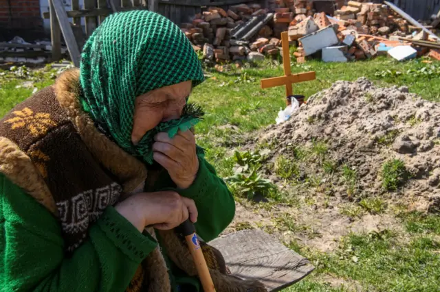 A woman next to her a grave