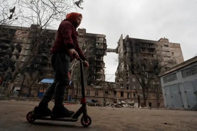 a boy rides a scooter in Mariupol