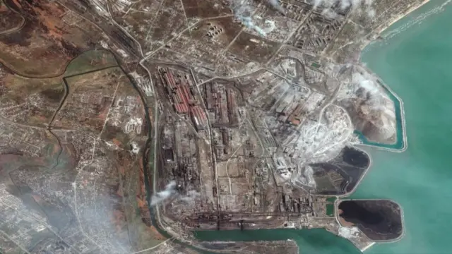 A satellite image shows a heavily industrialised area on the coast