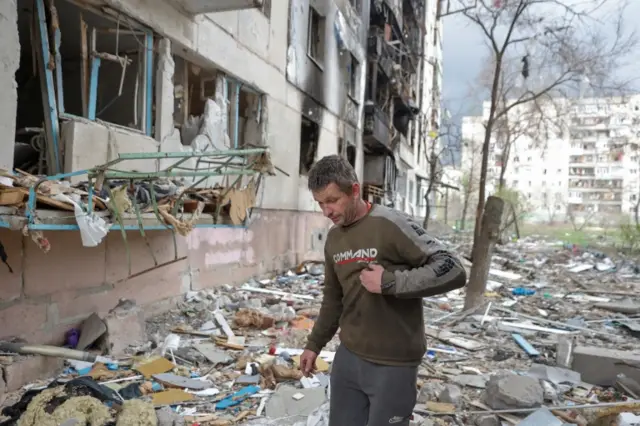 Local resident Viacheslav walks on debris of a residential building damaged by a military strike, as Russia"s attack on Ukraine continues, in Sievierodonetsk, Luhansk region, Ukraine April 16, 2022