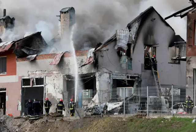 Firefighters battle a blaze after a civilian building was hit by a Russian missile in Lviv