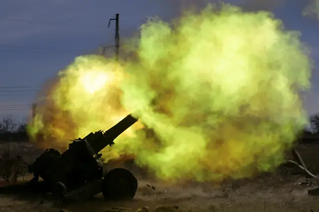 A member of the Ukrainian Volunteer Corps rests next to a howitzer