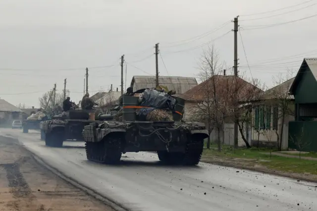 Ukrainian tanks drive through a village in the eastern Donetsk region