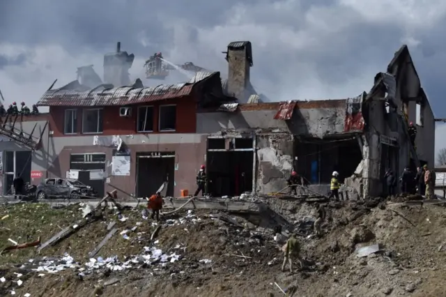 Firefighters work at the site of missile strikes on buildings in the western Ukrainian city of Lviv