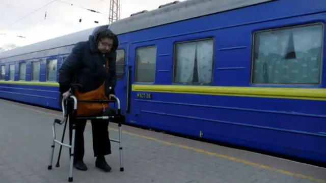 A woman walks to board an evacuation train at a station, amid Russia's invasion of Ukraine, in Odesa