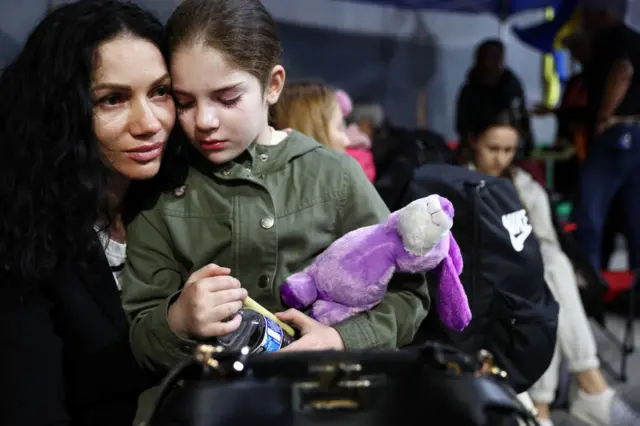 A Ukrainian mother and daughter, who are seeking asylum in the U.S., wait to cross the U.S.-Mexico border at the San Ysidro Port of Entry amid the Russian invasion of Ukraine on April 5, 2022 in Tijuana, Mexico