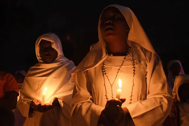 Women praying with candles