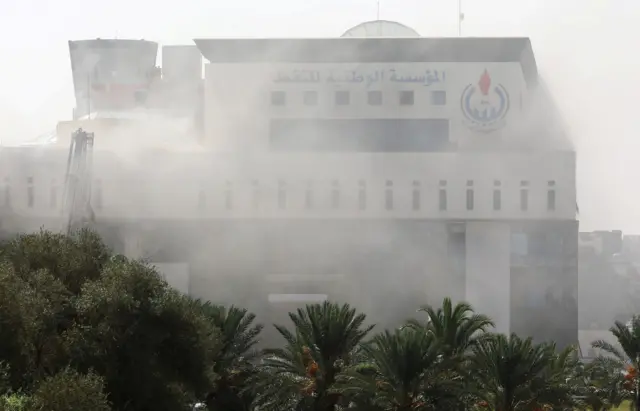 Smoke rises form the headquarters of Libyan state oil firm National Oil Corporation (NOC) after three masked persons attacked it in Tripoli