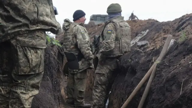 Ukrainian servicemen gathered in a trench in the Donbas region