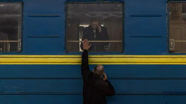 Bohdan Frank, says goodbye to his wife Yulia, as she with her daughter depart to the west of Ukraine on the evacuation train, at the railway station in Kharkiv