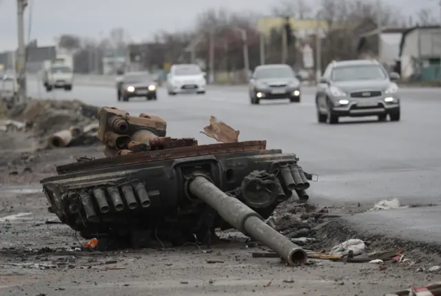 A part of damaged Russian tank lies on a road not far from the small city of Brovary near Kyiv