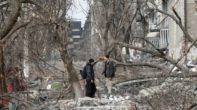 Local residents speak in a courtyard in Mariupol