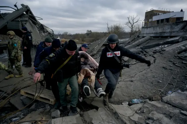 A woman is evacuated after shelling in Irpin, Ukraine.