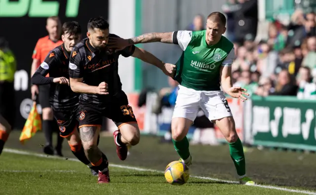 Harry Clarke dribbles past Tony Watt at Easter Road