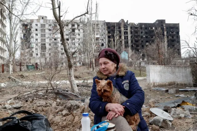 Raisa Isulina and dog, in ruins, 1 April 22