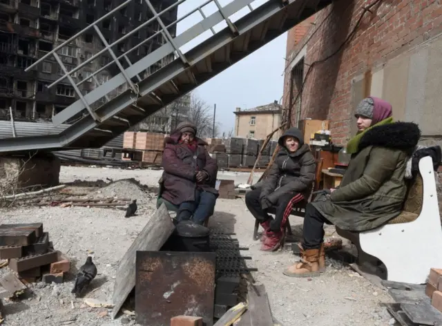 Group sitting around fire, 1 April 22