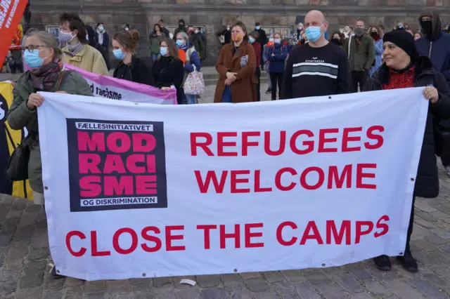 People along with a number of activists gather to protest the government's plan to deport Syrian refugees after Denmark refused to renew residency permits of Syrian refugees, as protest held by Mellemfolkelig Samvirke (Action Aid), Youth Branch of the Danish Refugee Council, Venligboerne and Syrian activist Haifaa Awad at Christiansborg Palace square near parliament building ,in Copenhagen, Denmark on April 21, 2021