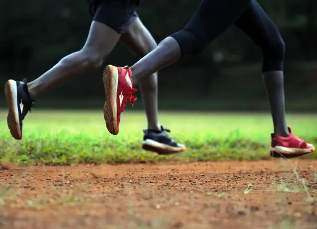 Young athletes run on a dirt track