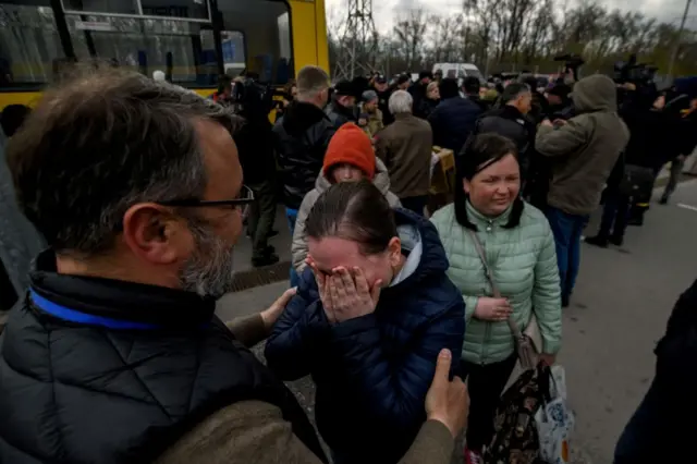 People fleeing fighting in the southern city of Mariupol meet relatives and friends as they arrive in a small convoy that crossed through territory held by Russian forces, after the opening of a humanitarian corridor, at a registration center for internally displaced people in Zaporizhzhia on 21 April 2022