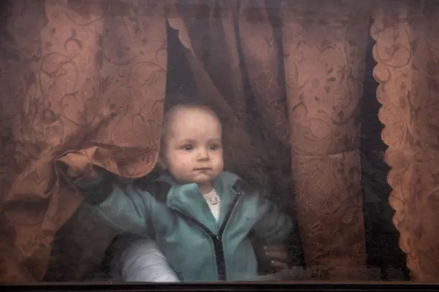 A baby looks out the window of a van after a convoy of vehicles arrived at an evacuation point, carrying people from Mariupol, Melitopol and surrounding towns under Russian control on 21 April 2022 in Zaporizhzhia, Ukraine.