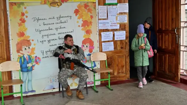 A Ukrainian soldier guards a school in Borodyanka