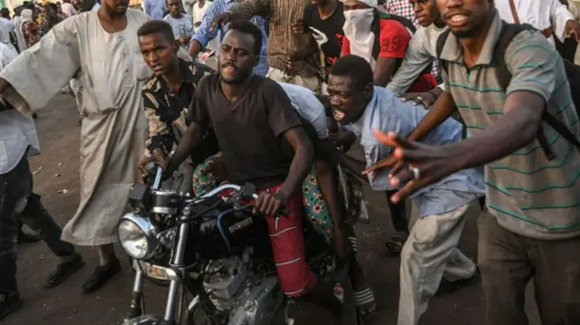 Man on motorbike with injured protester