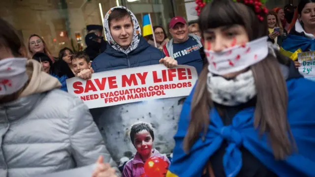 A protester in Warsaw on Friday calls for Mariupol evacuations