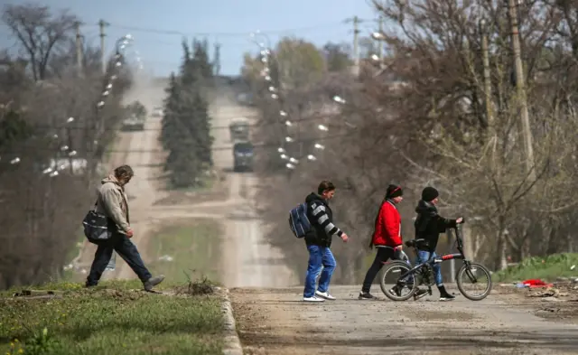 People cross a road in Mariupol