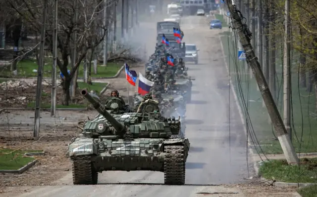 Armoured troops formed a convoy in Mariupol flying the flags of Russia and the self-proclaimed People's Republic of Luhansk