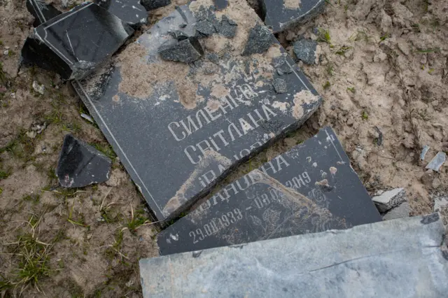 Image shows grave stone broken into pieces