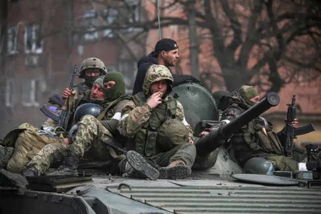 An armoured convoy of pro-Russian troops moves along a road in Mariupol