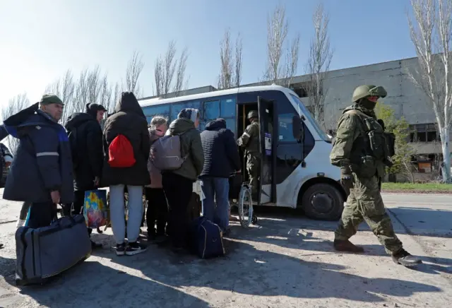 Evacuees queue to board a bus in Mariupol, Ukraine