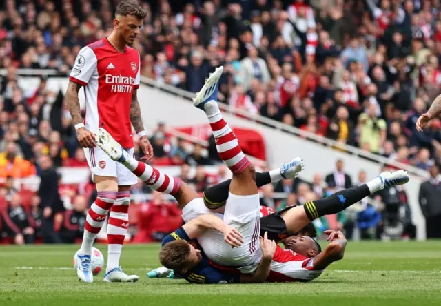 Gabriel and Scott McTominay tangle on the ground as Arsenal play Manchester United