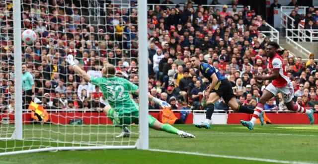 Diogo Dalot shoots against a post against Arsenal