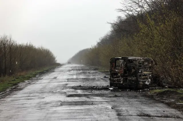 A burnt van is pictured on the empty way to Popasna earlier this month