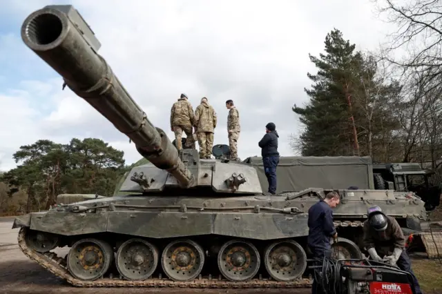 People standing on and around a Challenger 2 tank