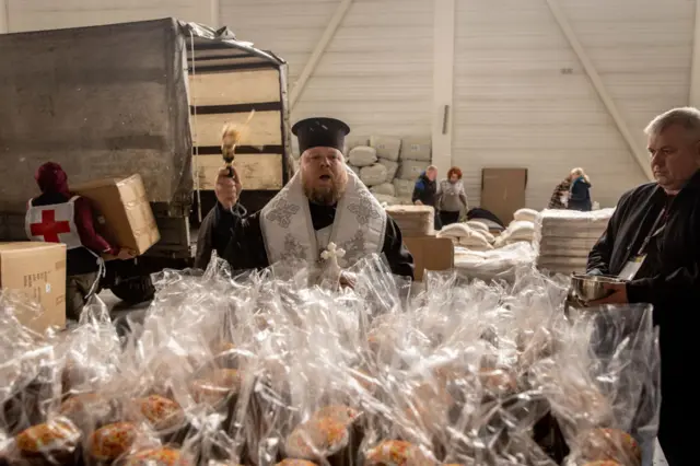 An Orthodox priest blesses Easter cakes ahead of Orthodox Easter at a humanitarian aid facility in Zaporizhzhia