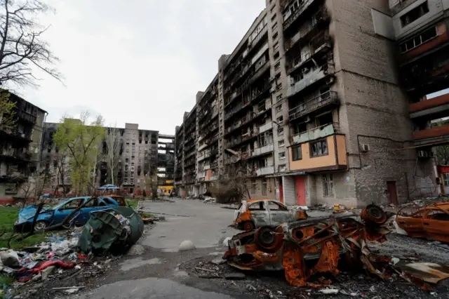 A view shows damaged residential buildings and cars in the southern port city of Mariupol, Ukraine, on 22 April 2022.