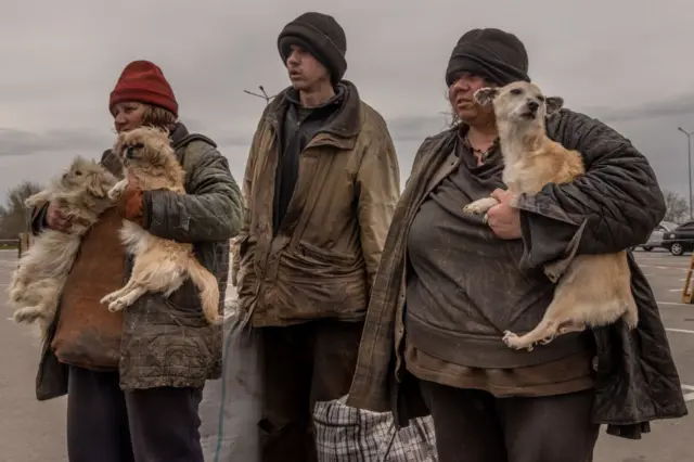 A family wait at an evacuation point in Zaporizhzhia